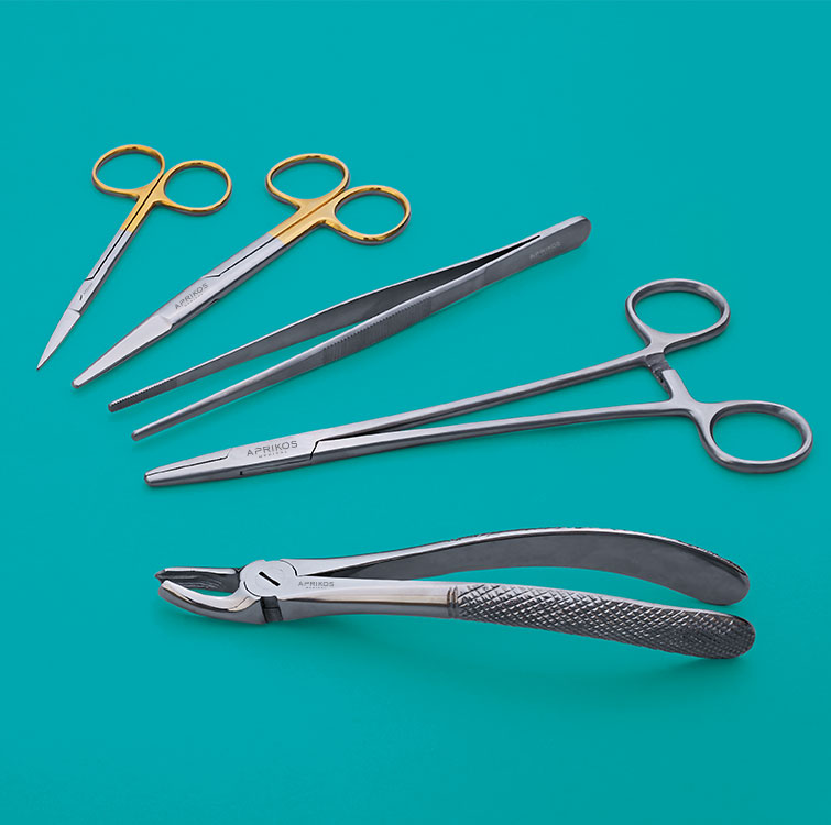 Some steel surgical instruments laying on a surface.